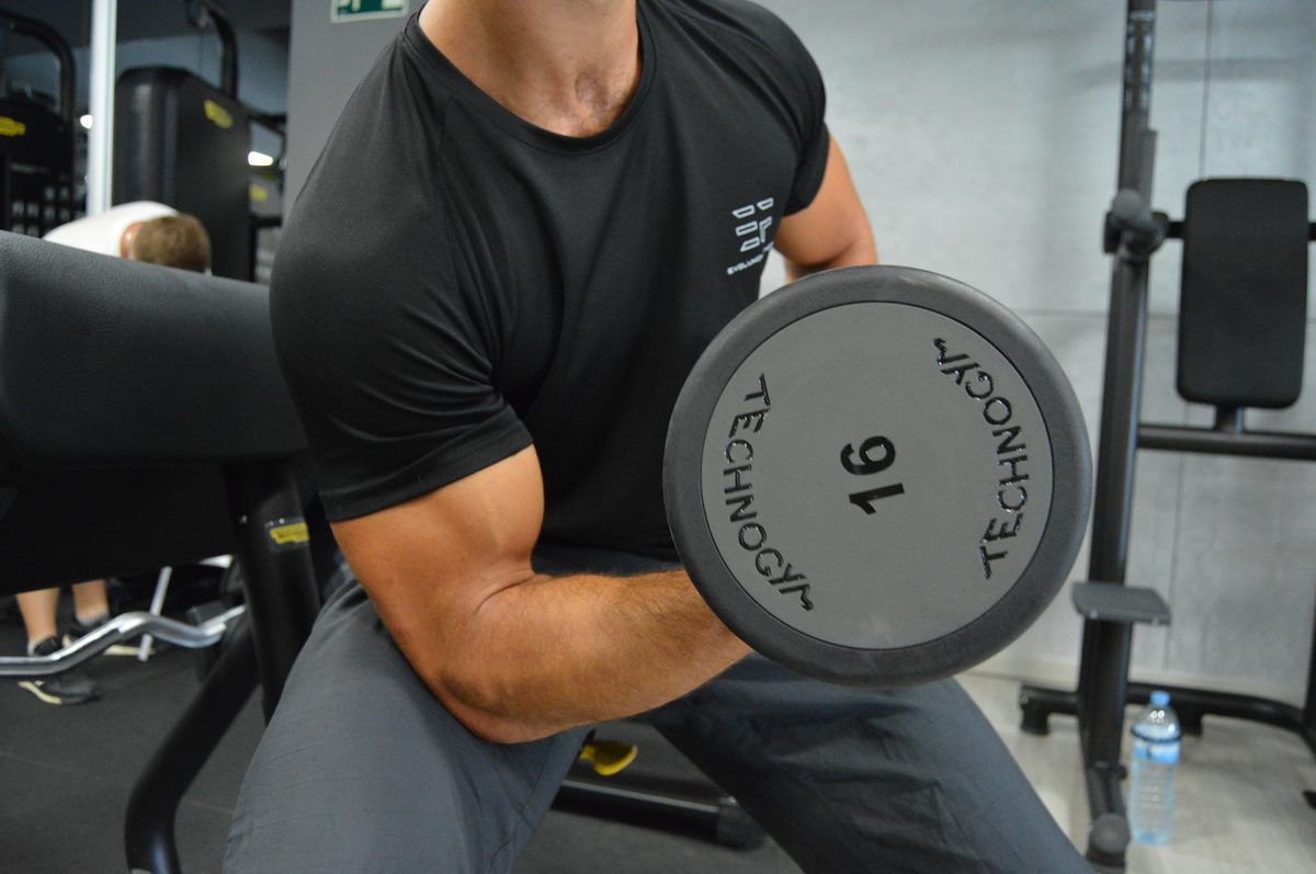 Evoluxion coach guiding a client through a gym exercise